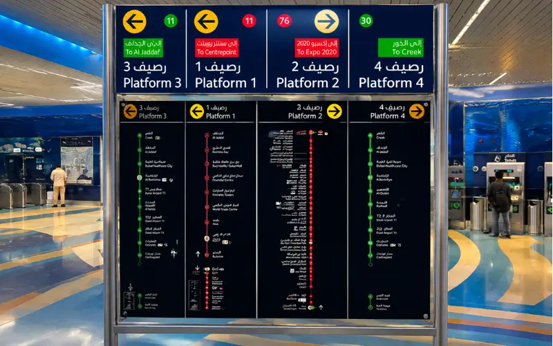 BurJuman Metro Station platform signs showing Red Line and Green Line directions with clear metro route maps and station information.
